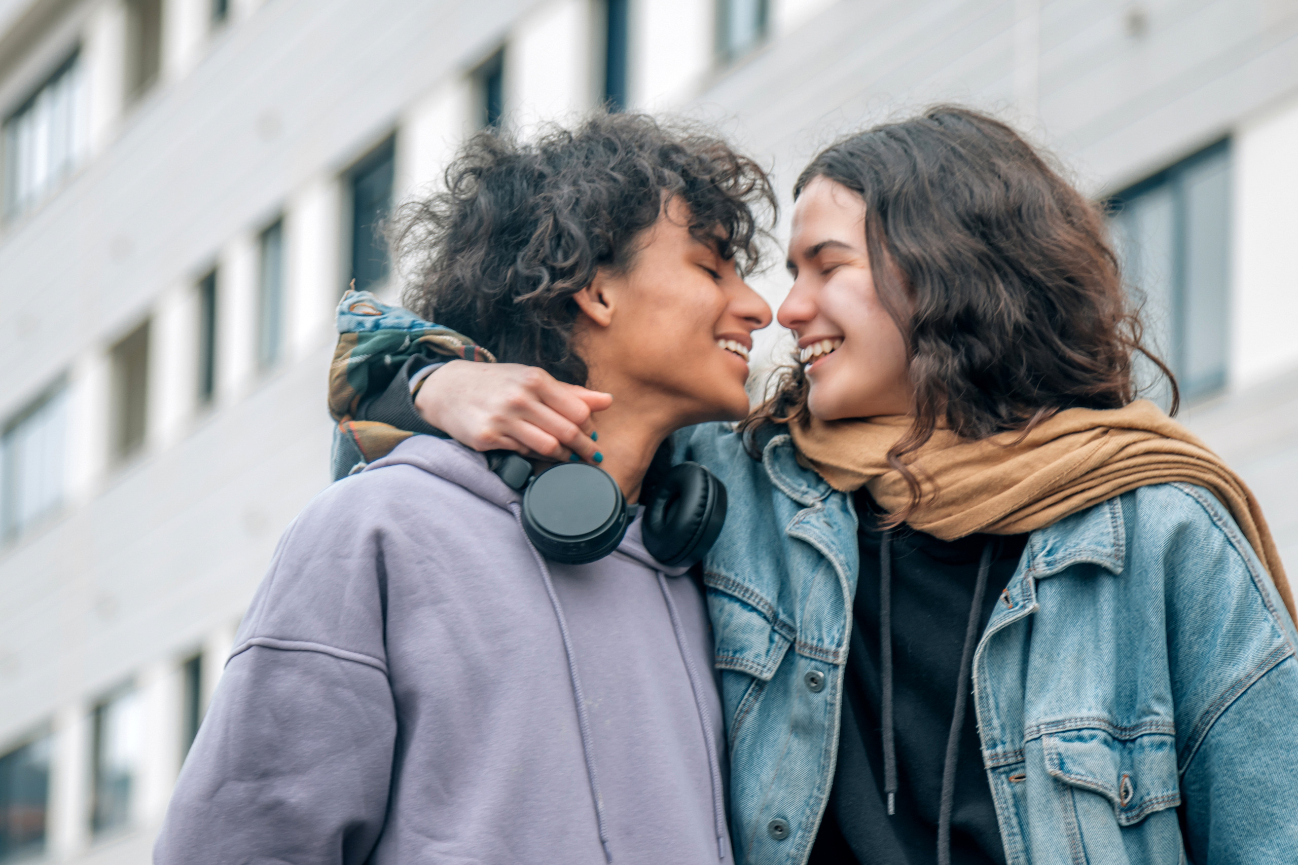 happy teenage couple kissing on the street